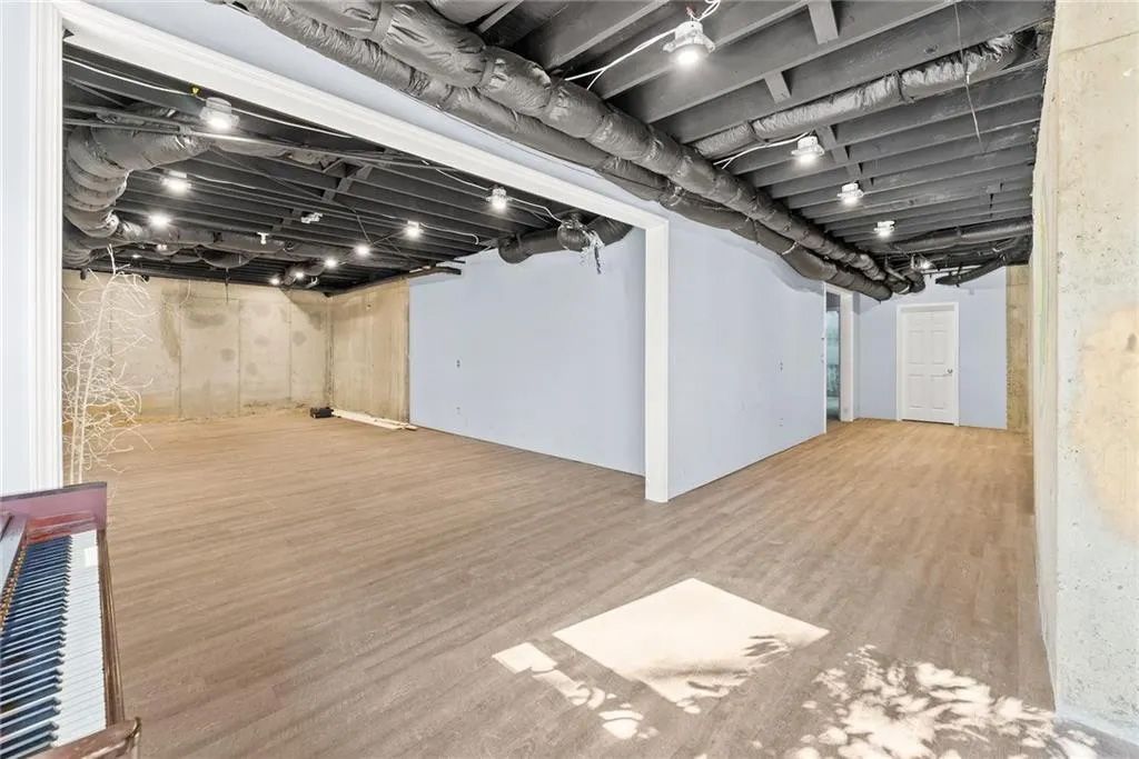 A large empty room with a wooden floor and a ceiling.